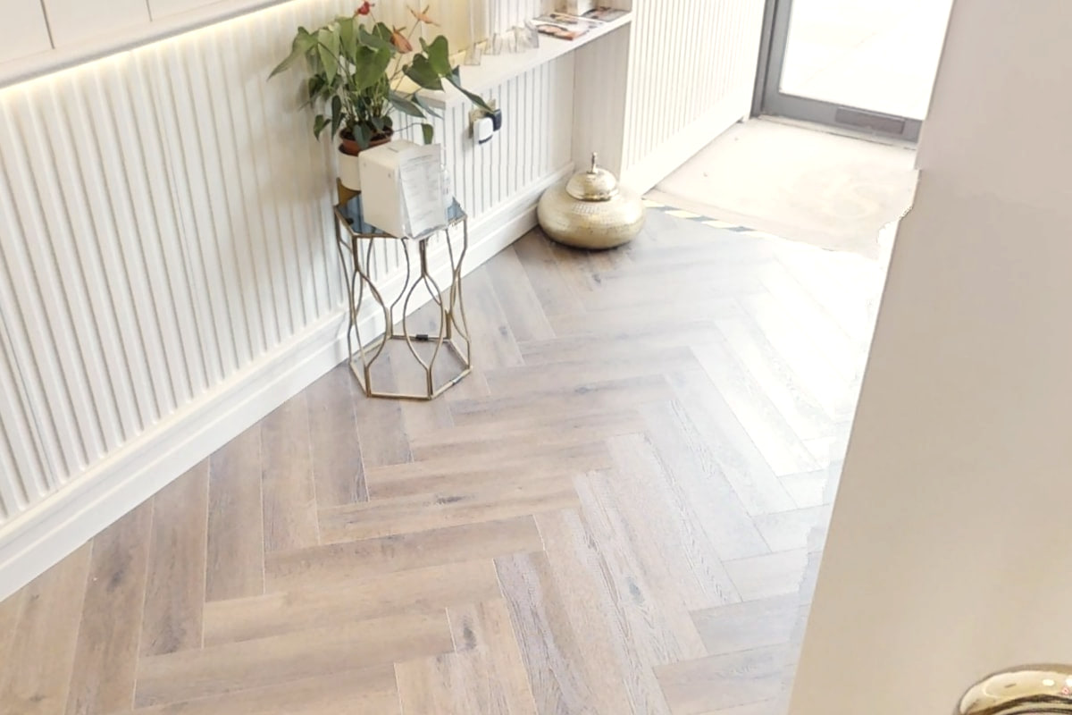 Herringbone flooring and a brass pot beside the panelled wall at Shirland Dental Practice