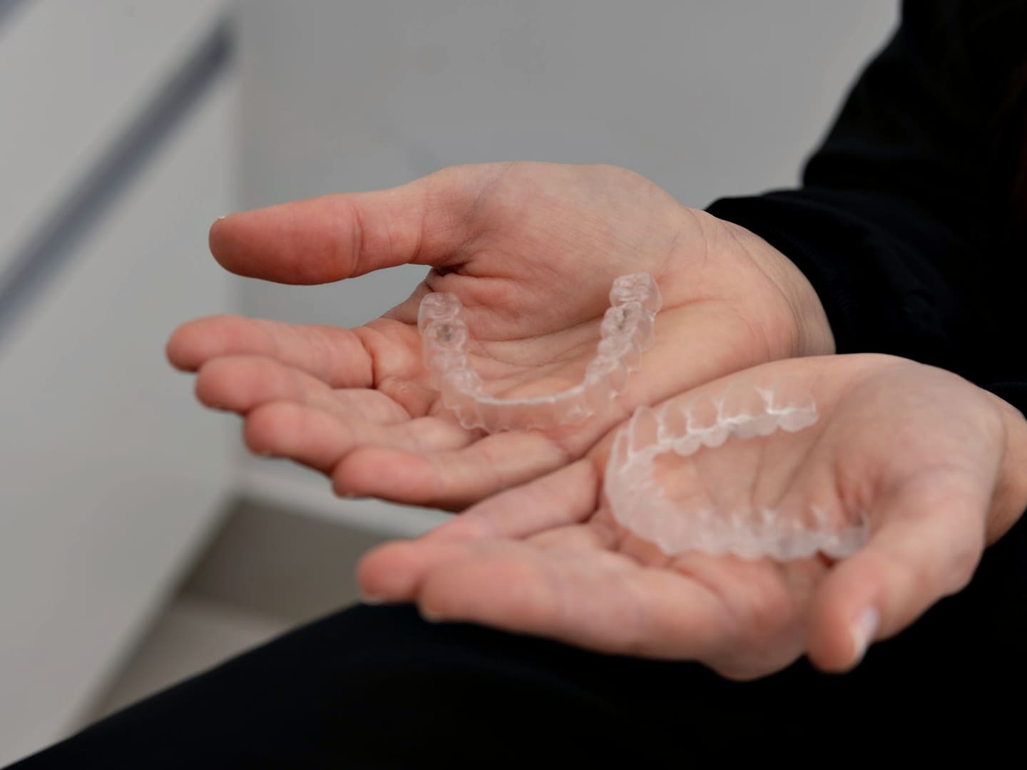 Dentist holding a set of clear aligners in the clinic