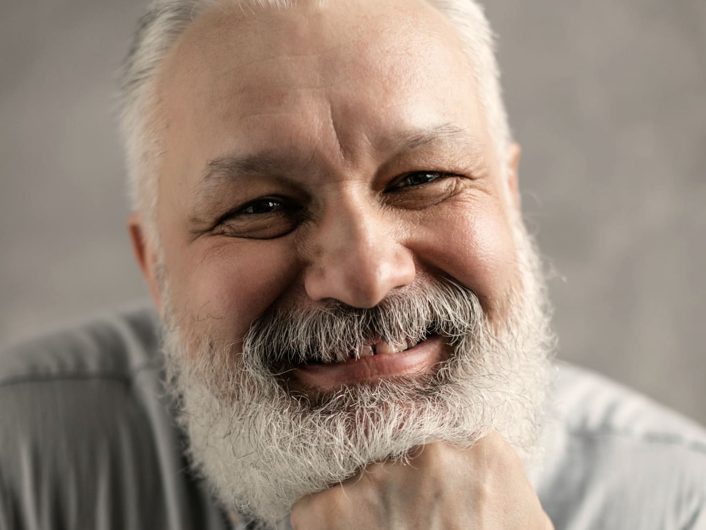 Older man smiling comfortably with a full set of teeth